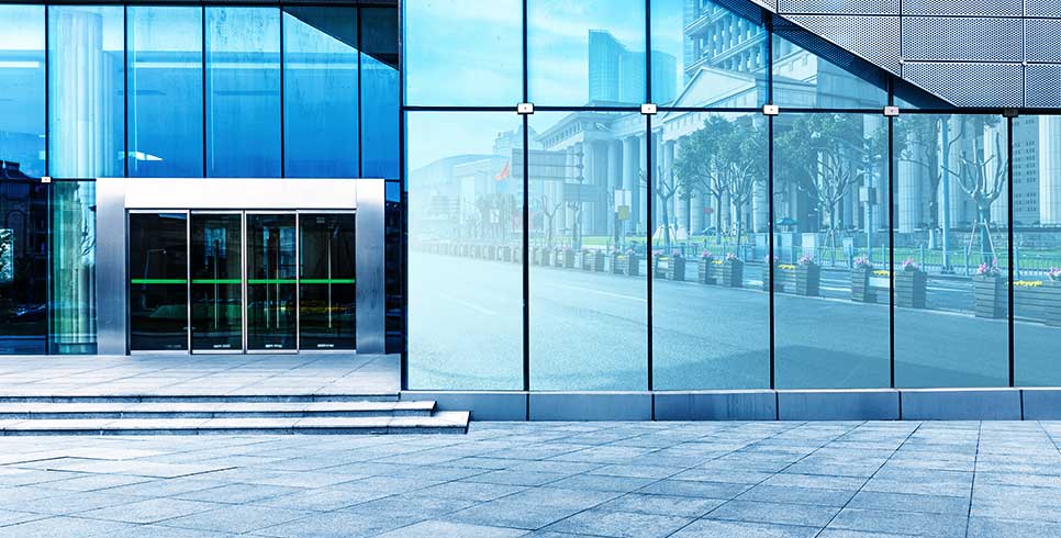 Outside office building entrance with glass walls and windows