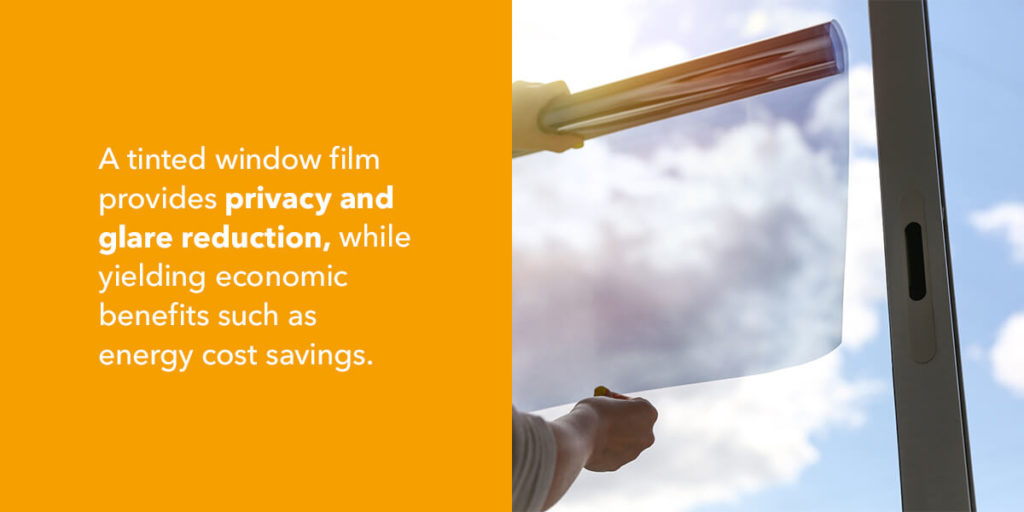 A tinted window film provides privacy and glare reduction, while yielding economic benefits such as energy cost savings.