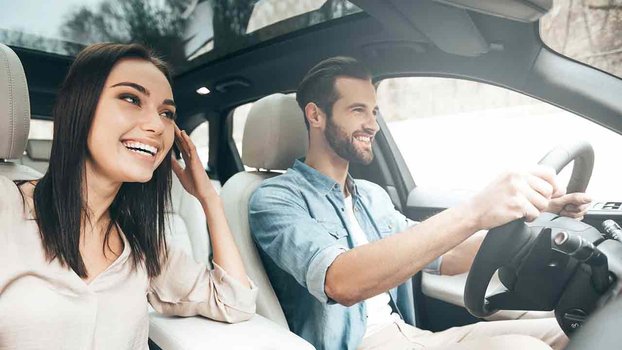 couple in car having good time with sunroof open